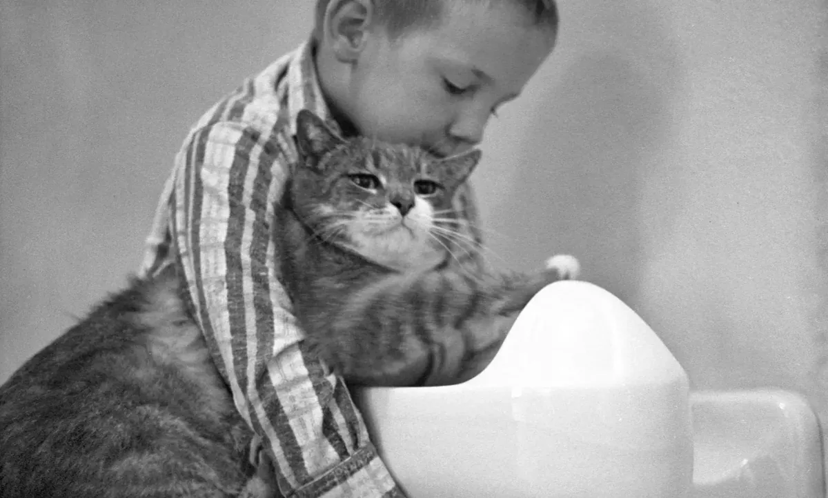 A student hugging Room 8 at a school drinking fountain