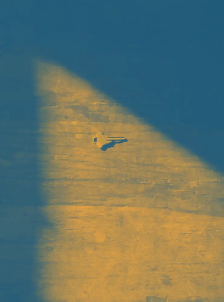 A key on the floor in a shaft of light